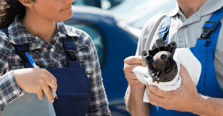 Mechanic holding an alternator, showing to a customer